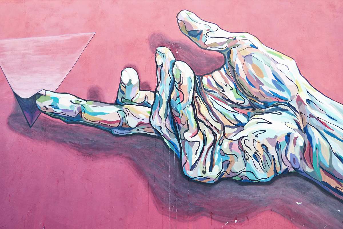 modern art hand holding pyramid painting street